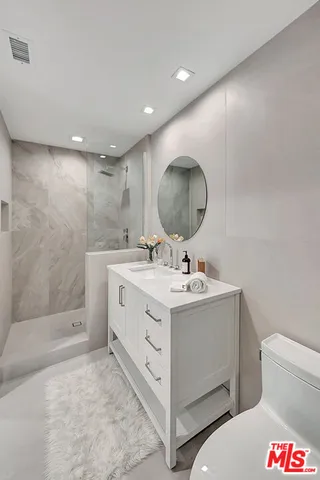 a bathroom with a sink a toilet and a mirror