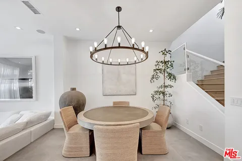 a dining room with furniture a chandelier and wooden floor