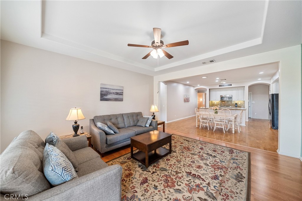 28713 Raintree Drive Menifee, CA 92584 - Photo 16 of 56 a living room with furniture and a dining table with wooden floor