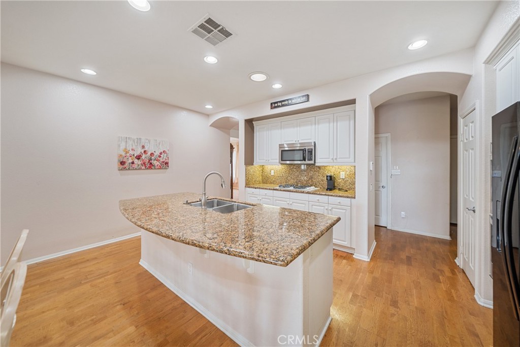28713 Raintree Drive Menifee, CA 92584 - Photo 18 of 56 a kitchen with stainless steel appliances granite countertop a sink and a refrigerator