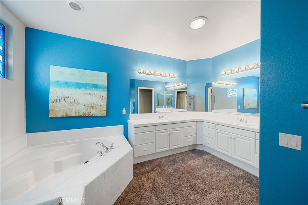 28713 Raintree Drive Menifee, CA 92584 - Photo 22 of 56 a bathroom with a tub sink and mirror
