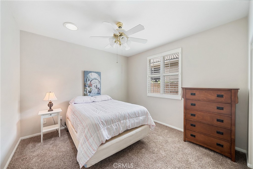 28713 Raintree Drive Menifee, CA 92584 - Photo 25 of 56 a bedroom with a bed and a chandelier