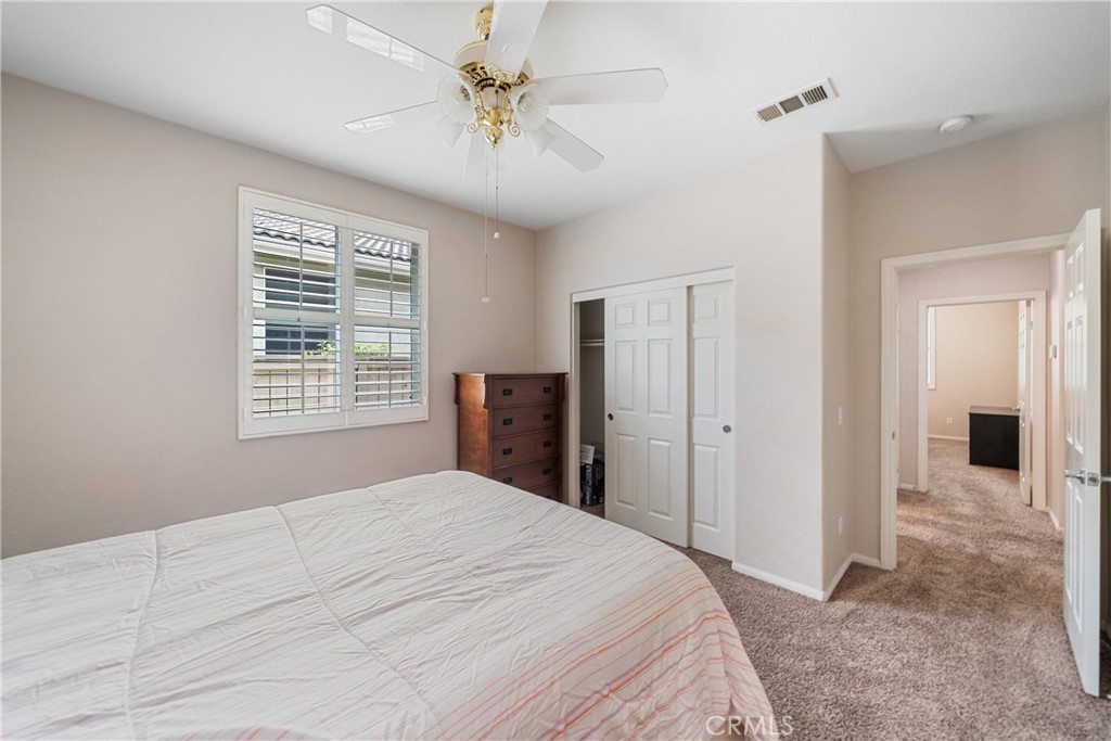 28713 Raintree Drive Menifee, CA 92584 - Photo 26 of 56 a bedroom with a large bed and a chandelier