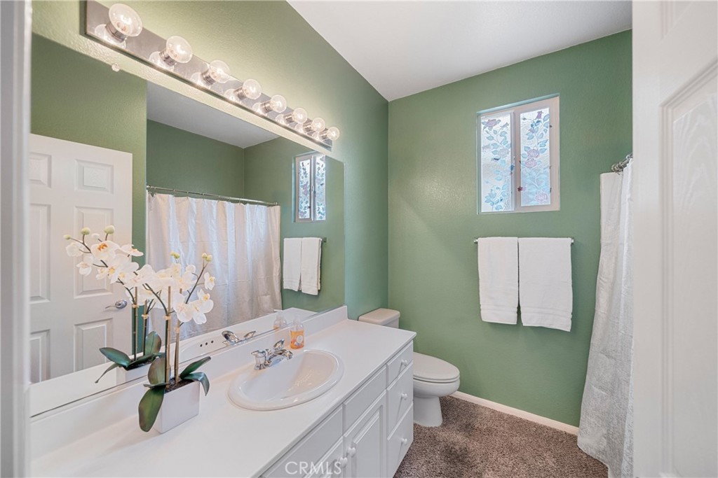 28713 Raintree Drive Menifee, CA 92584 - Photo 27 of 56 a bathroom with a sink a toilet and mirror