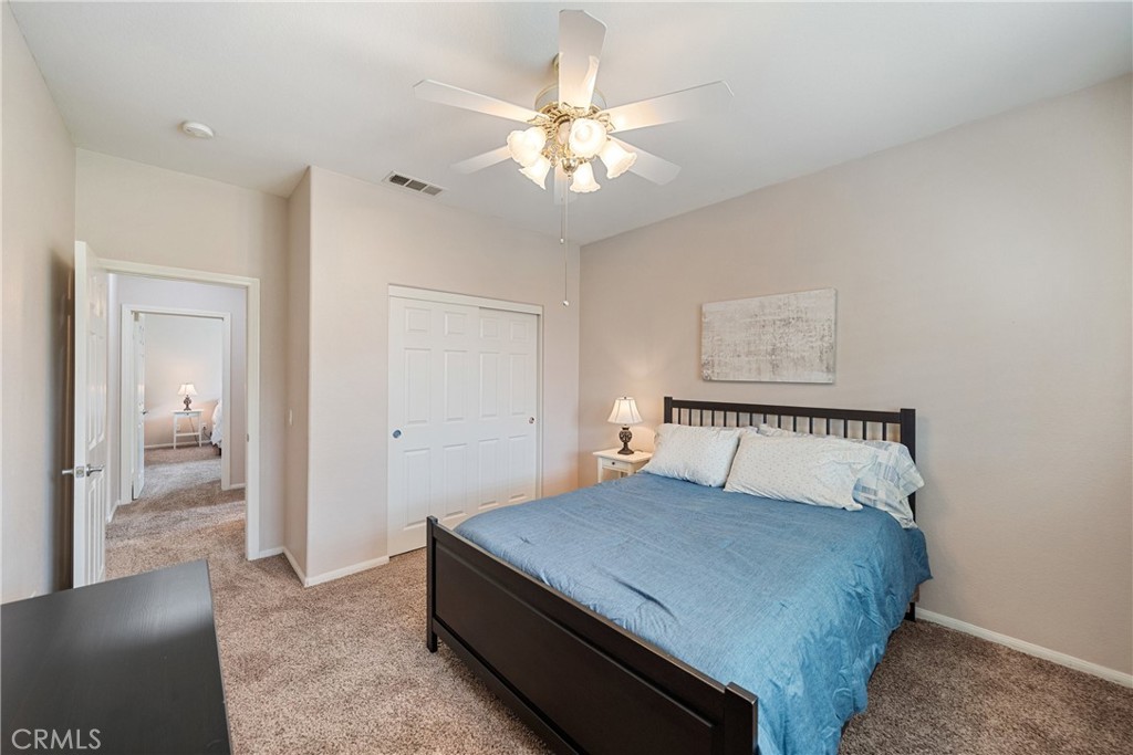28713 Raintree Drive Menifee, CA 92584 - Photo 30 of 56 a bedroom with a bed and a chandelier