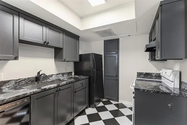 a kitchen with a stove a refrigerator and a sink