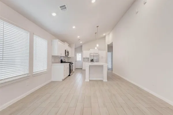 a view of kitchen with wooden floor and electronic appliances