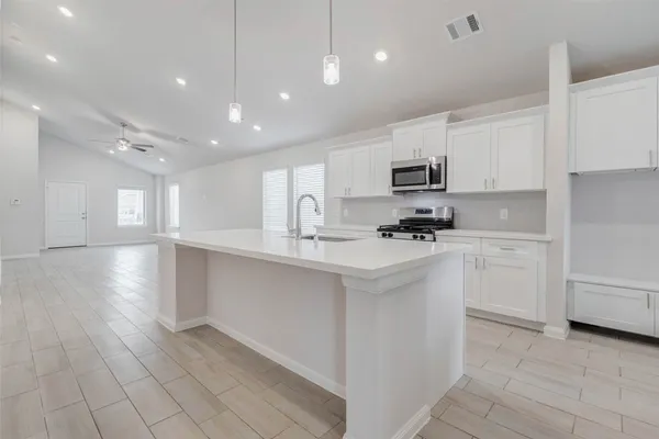 a kitchen with white cabinets and appliances
