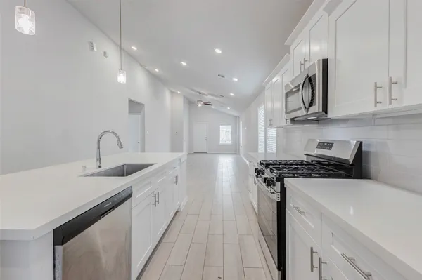 a kitchen with a sink a stove and a refrigerator