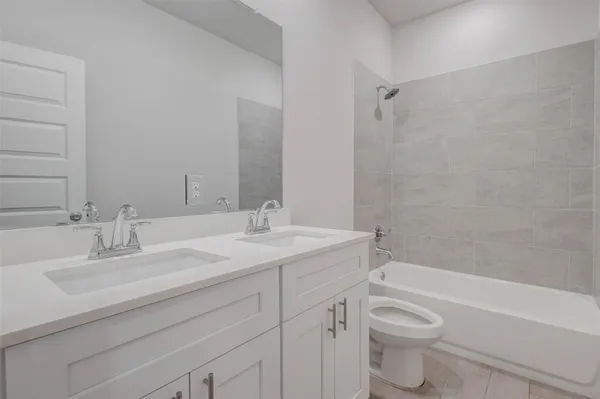 a bathroom with a granite countertop sink a toilet and a bathtub