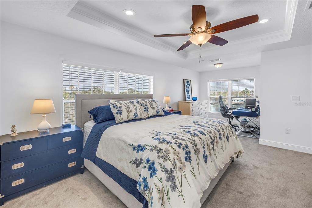 100 Windrush Boulevard, Unit 1 Indian Rocks Beach, FL 33785 - Photo 14 of 37 a bedroom with a bed and a chandelier