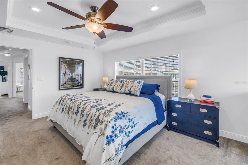 100 Windrush Boulevard, Unit 1 Indian Rocks Beach, FL 33785 - Photo 15 of 37 a bedroom with a bed and a chandelier