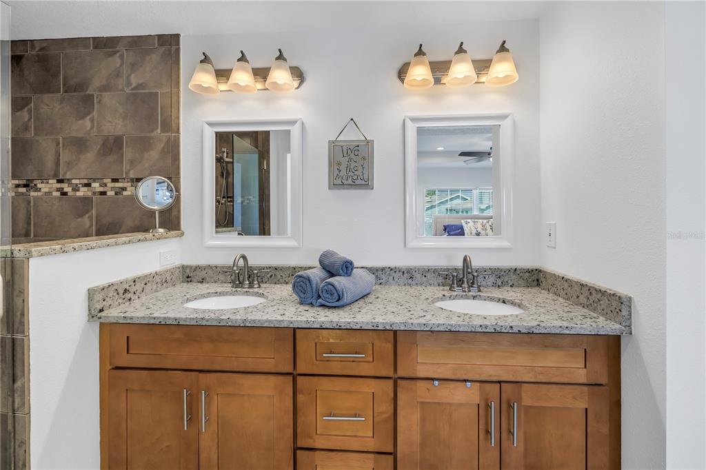 100 Windrush Boulevard, Unit 1 Indian Rocks Beach, FL 33785 - Photo 19 of 37 a bathroom with a granite countertop sink and a mirror