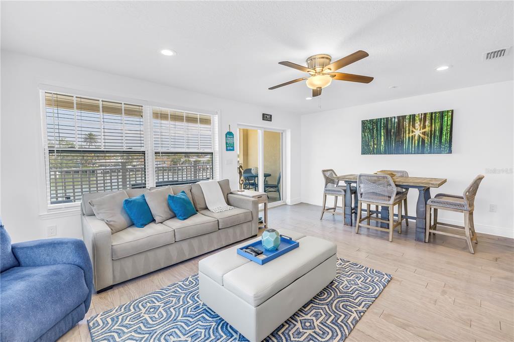 100 Windrush Boulevard, Unit 1 Indian Rocks Beach, FL 33785 - Photo 7 of 37 a living room with furniture a ceiling fan and a rug