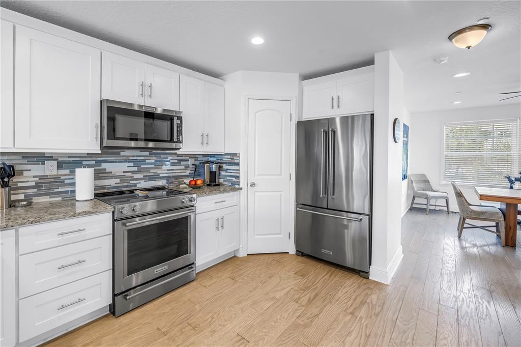 100 Windrush Boulevard, Unit 1 Indian Rocks Beach, FL 33785 - Photo 10 of 37 a kitchen with stainless steel appliances a refrigerator stove and microwave