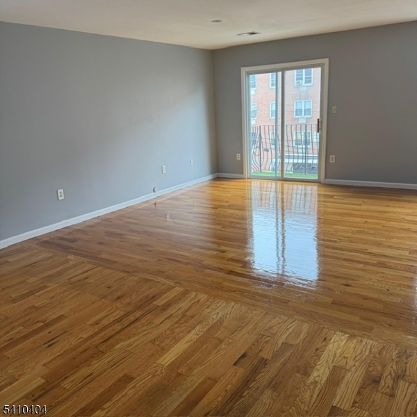 89 Chadwick Avenue, Unit 3 Newark, NJ 07108 - Photo 28 of 28 an empty room with wooden floor and windows