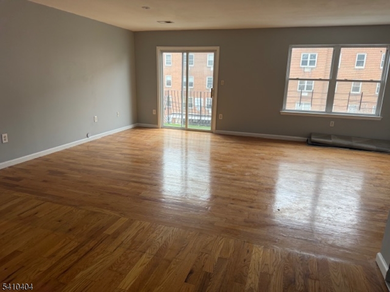 89 Chadwick Avenue, Unit 3 Newark, NJ 07108 - Photo 3 of 28 a view of empty room with wooden floor and fan