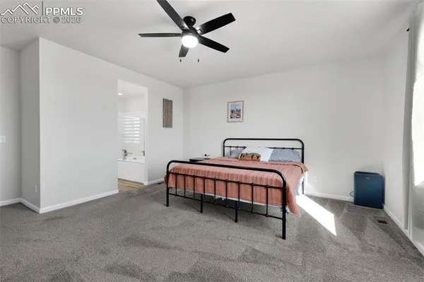 a spacious bedroom with a bed and a ceiling fan