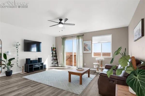 a living room with furniture a flat screen tv and a window