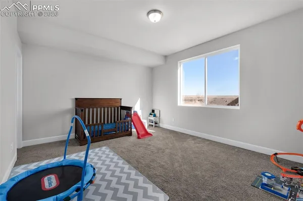 a view of an empty room with window and a wooden floor