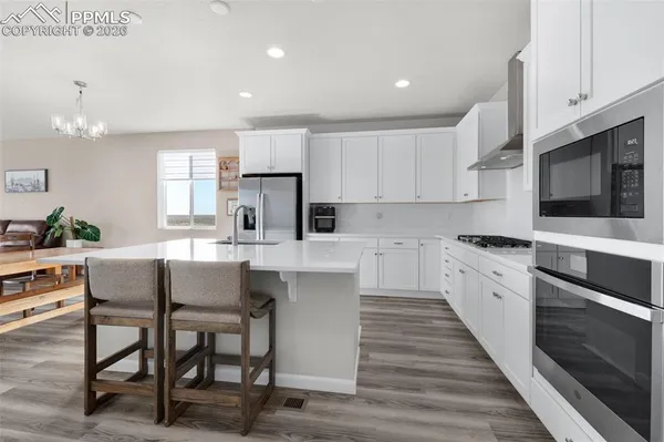 a kitchen with a table chairs microwave and cabinets