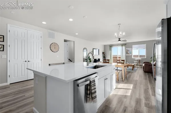 a large kitchen with a lot of counter space and wooden floor