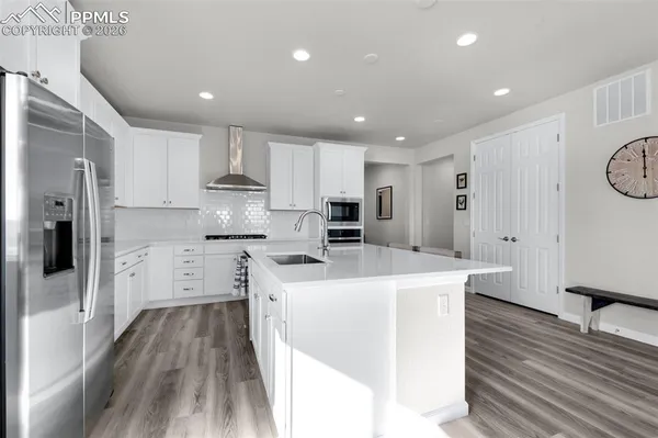 a kitchen with stainless steel appliances a refrigerator a stove top oven and a refrigerator