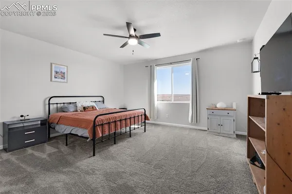 a spacious bedroom with a bed and a chandelier