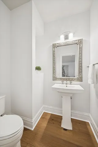 a bathroom with a toilet a sink and mirror