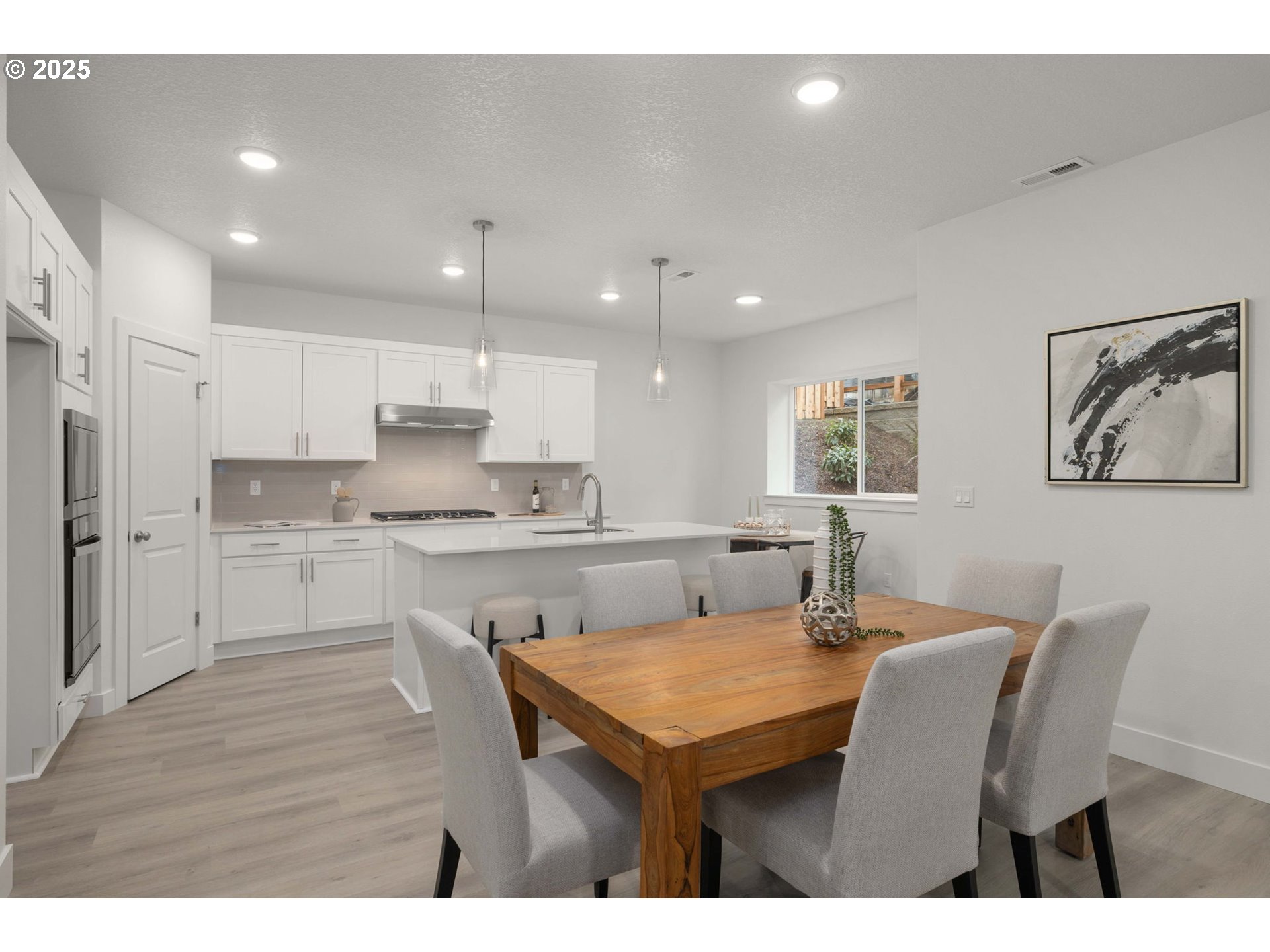 19040 Southwest Northridge Court, Unit LOT 15 Beaverton, OR 97007 - Photo 11 of 34 a kitchen with a table chairs refrigerator and cabinets