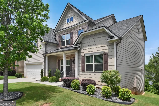 a front view of a house with a yard and potted plants