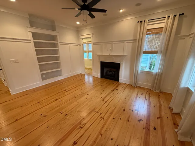 a kitchen with a stove a sink a chandelier and living room view