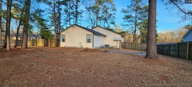 a view of a house with a backyard and tree