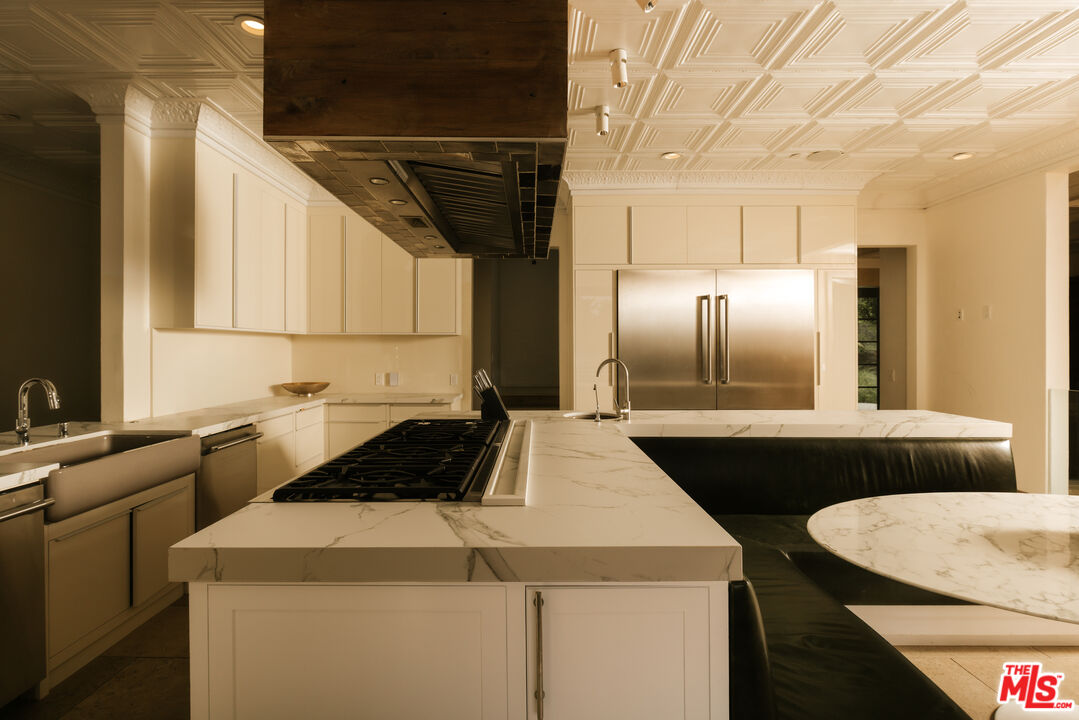 1105 Rivas Canyon Road Pacific Palisades, CA 90272 - Photo 24 of 49 a kitchen with kitchen island a counter top a stove and a refrigerator