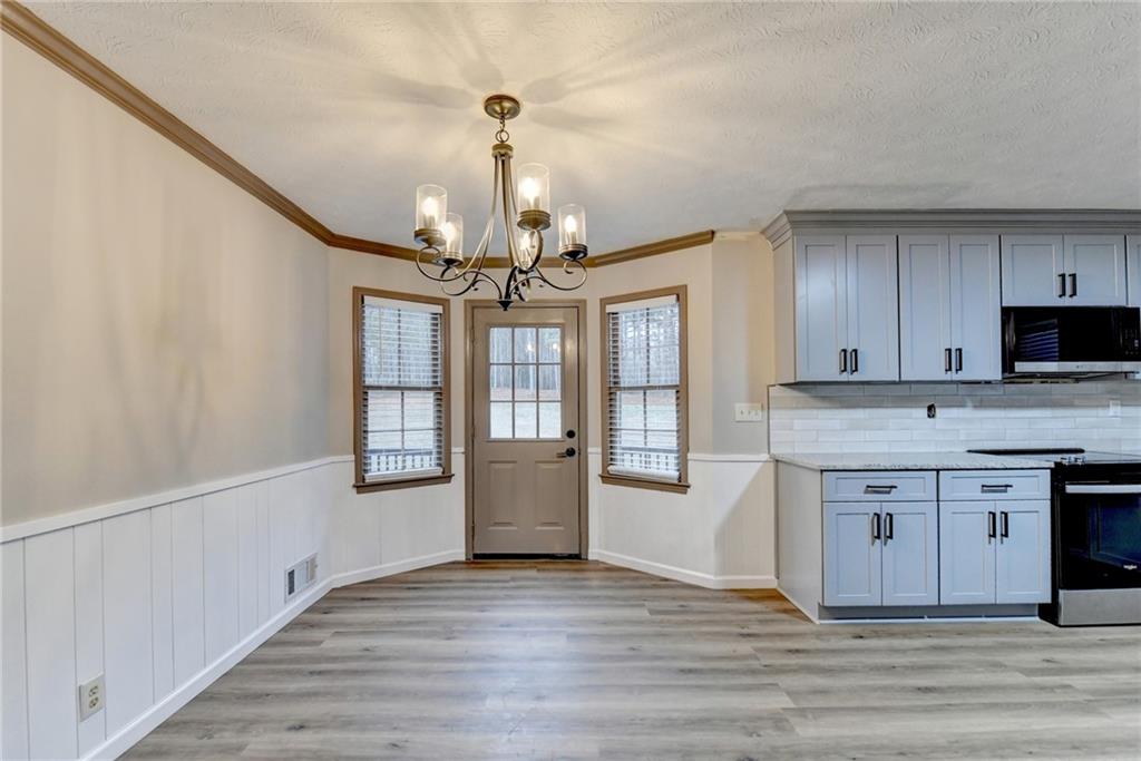 2377 Centerville Rosebud Road Loganville, GA 30052 - Photo 18 of 76 a view of a kitchen with granite countertop stainless steel appliances and wooden floor