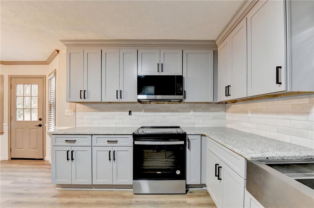 2377 Centerville Rosebud Road Loganville, GA 30052 - Photo 22 of 76 a kitchen with granite countertop white cabinets and stainless steel appliances