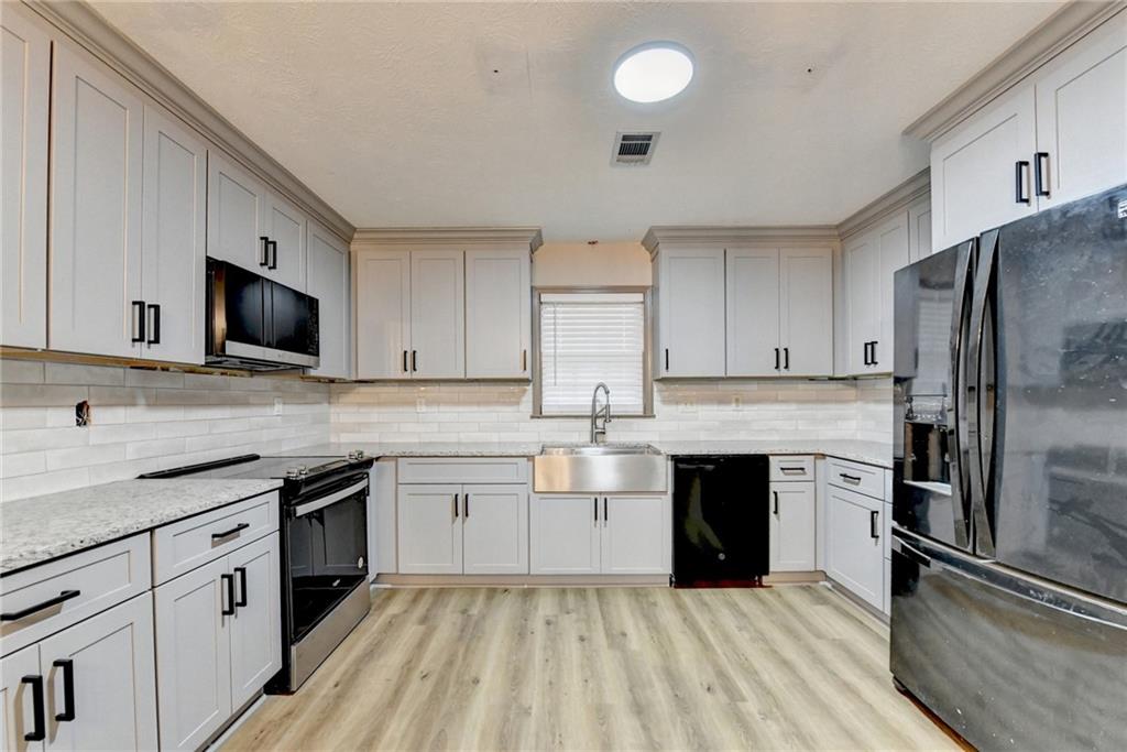 2377 Centerville Rosebud Road Loganville, GA 30052 - Photo 23 of 76 a kitchen with a sink stainless steel appliances and cabinets