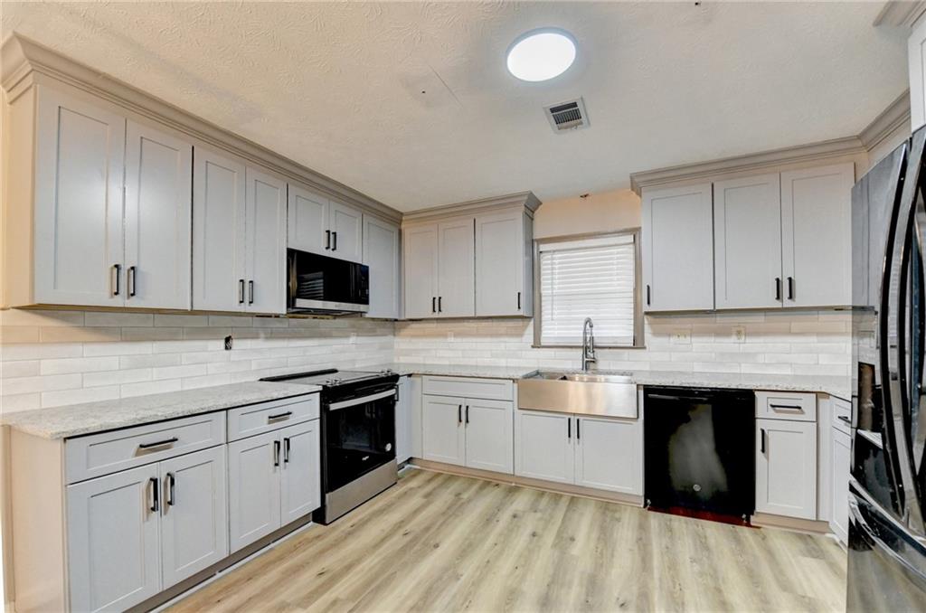 2377 Centerville Rosebud Road Loganville, GA 30052 - Photo 24 of 76 a kitchen with granite countertop a sink stainless steel appliances and cabinets