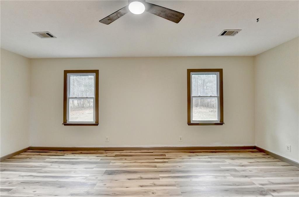 2377 Centerville Rosebud Road Loganville, GA 30052 - Photo 30 of 76 a view of an empty room with wooden floor and a window
