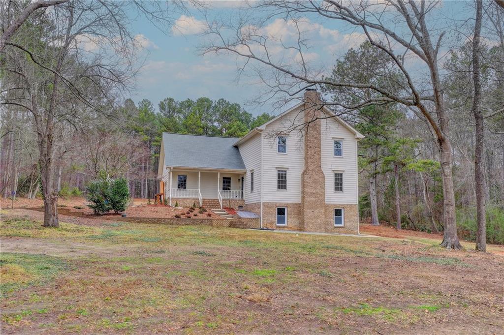 2377 Centerville Rosebud Road Loganville, GA 30052 - Photo 4 of 76 a front view of house with yard and trees in the background