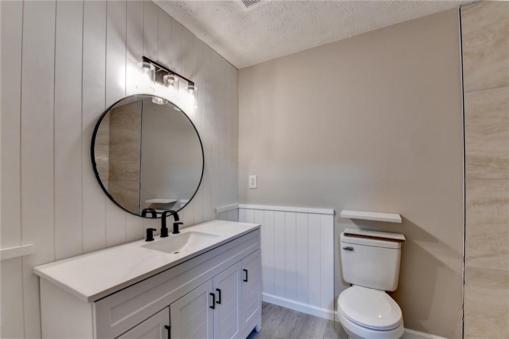 2377 Centerville Rosebud Road Loganville, GA 30052 - Photo 44 of 76 a bathroom with a toilet a sink and mirror
