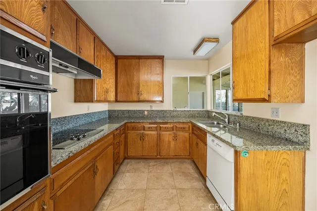 a kitchen with granite countertop a sink and cabinets
