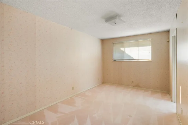 a view of an empty room with closet and a window