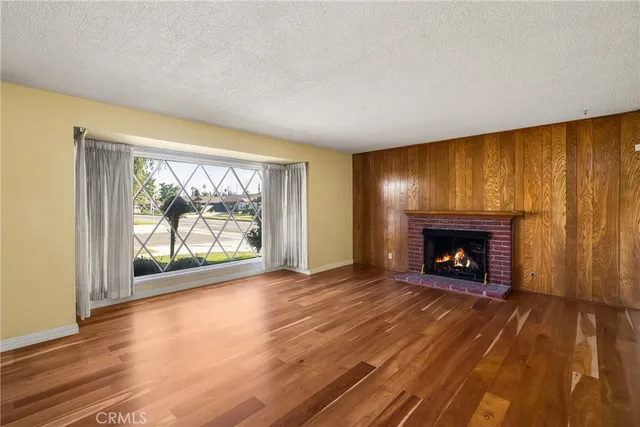 a view of an empty room with a fireplace and a window