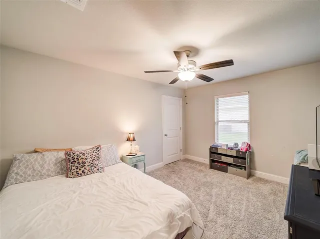 a bedroom with a bed and a ceiling fan