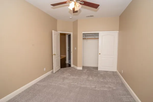 an empty room with chandelier fan