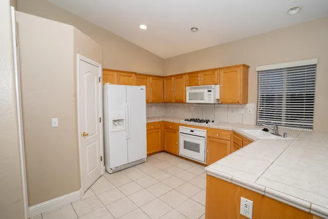 a kitchen with stainless steel appliances granite countertop a refrigerator and a stove top oven