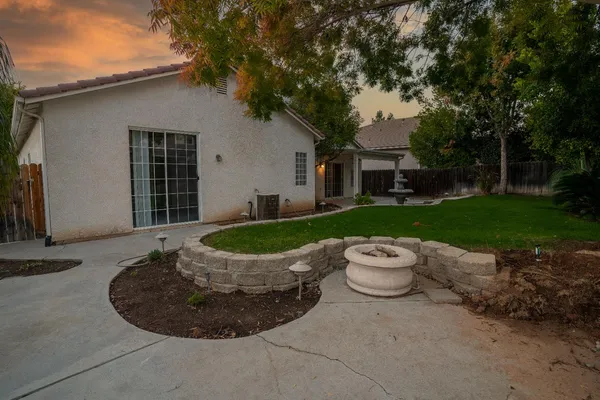 a view of a house with backyard sitting area and garden