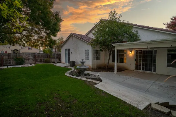 a view of a backyard with table and chairs and wooden fence