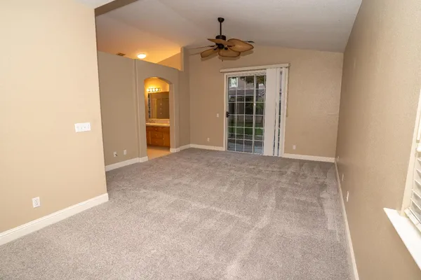 a view of a livingroom with a chandelier fan and a window